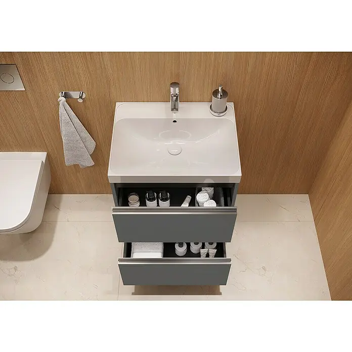 Riva Urban 2.0 Waschtischunterschrank - B x T x H: 60 x 45,1 x 63,5 cm, Anthrazit - Ein modernes Badezimmerwaschbecken mit zwei offenen Schubladen und verschiedenen Badutensilien, stilvoll präsentiert vor einem Holzhintergrund.
