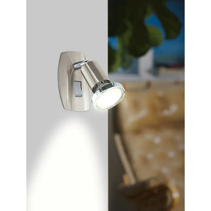 Eglo Mini 4 Steckdosenspot - 3 W, Chrom - Nahaufnahme einer modernen Wandleuchte aus Chrom, die Licht auf eine weiße Wand wirft und eine gemütliche Atmosphäre erzeugt.
