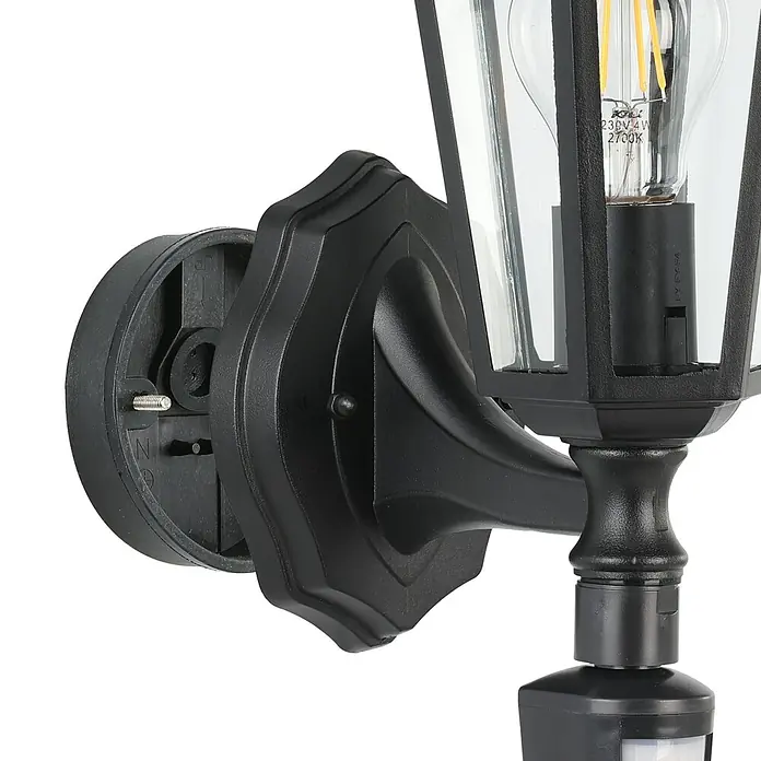 Eglo Laterna 4 Außenwandleuchte - 60 W, Schwarz, Klar, IP44, Bewegungsmelder - Nahaufnahme einer schwarzen Außenwandleuchte mit Bewegungssensor und klarem Glasschirm, die eine dekorative Glühbirne zeigt.