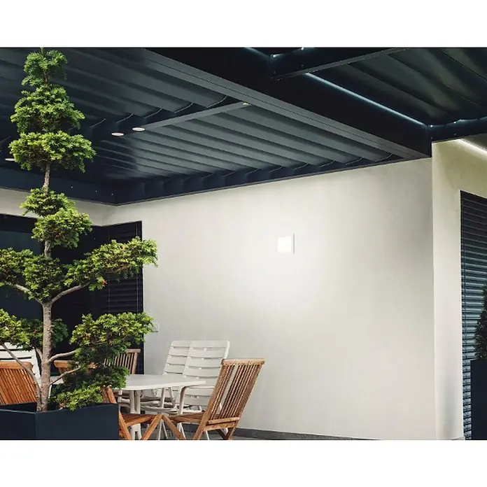 Briloner Plafón LED para exterior Frankfurt - 8 W, L x An x Al: 190 x 190 x 28 mm, Blanco, IP44 - Foto exterior de una mesa y sillas bajo una pérgola, con una planta en maceta.