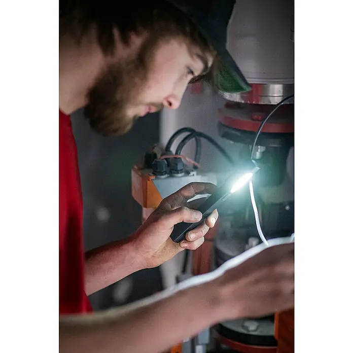 Ledlenser LED-Arbeitsleuchte Stiftleuchte W2R Work - 160 lm, Lichtfarbe: Kaltweiß, IP54 - Person nutzt eine schwarze Handtaschenlampe zur Inspektion von Maschinen.