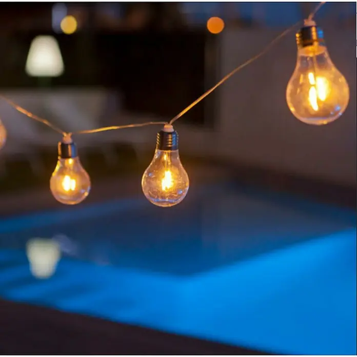 New Garden Lámpara decorativa solar Stella - Blanco cálido, Largo: 4,5 m, Transparente - Guirnalda de luces con bombillas que iluminan un espacio exterior, creando un ambiente cálido y acogedor. Ideal para fiestas y noches.