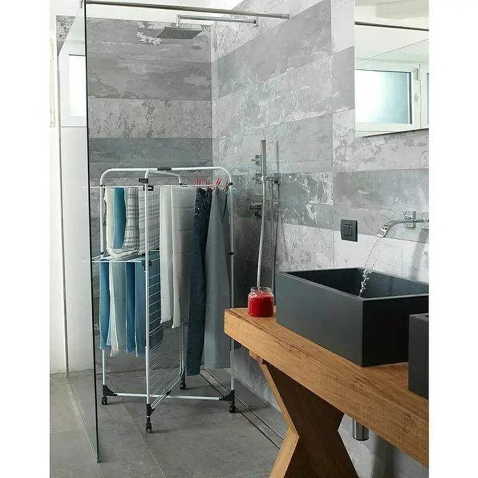 Vileda Turm-Wäscheständer Level 3 - Länge Wäscheleine: 33 m, L x B x H: 69 x 74 x 130 cm, Weiß/Anthrazitgrau - Ein Wäscheständer mit mehreren Kleidungsstücken in einem modernen Badezimmer. Praktische Trocknungslösung für den Alltag.