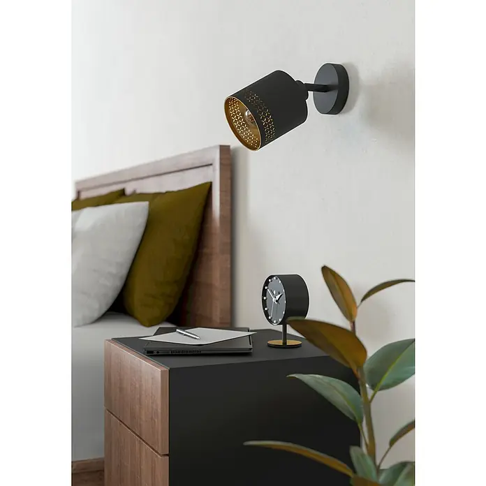 Eglo Esteperra Deckenstrahler ESTEPERRA - 28 W, Schwarz, E27, 1 Stk. - Moderne Schlafzimmer-Szene mit einer stilvollen schwarzen Wandleuchte, Nachttisch mit Uhr, Notizbuch und einer Zimmerpflanze.
