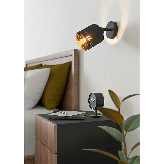 Eglo Esteperra Deckenstrahler ESTEPERRA - 28 W, Schwarz, E27, 1 Stk. - Nahaufnahme einer modernen schwarzen Wandleuchte mit goldenem Innenraum, die ein warmes Licht in einem stilvollen Schlafzimmer verbreitet.