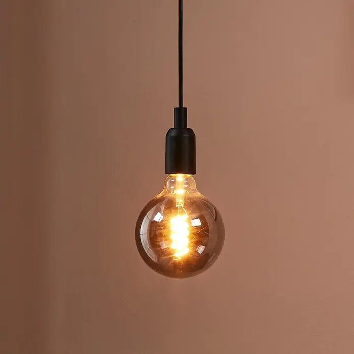 Eglo LED-Lampe - E27, Dimmbar, Warmweiß, 100 lm, 4 W - Nahaufnahme einer Edison-Glühbirne mit Glühfaden an einem schwarzen Kabel vor einem schlichten, braunen Hintergrund.