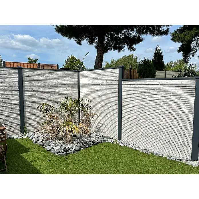 Beckers Betonzaun Zaunelement Klassik Toscana Motiv - 184 x 26 cm, Beton, Betongrau - Der Fokus liegt auf einem modernen Sichtschutzzaun mit grauen Paneelen und einer dezenten Steinoptik, umgeben von einem gepflegten Gartenbereich.
