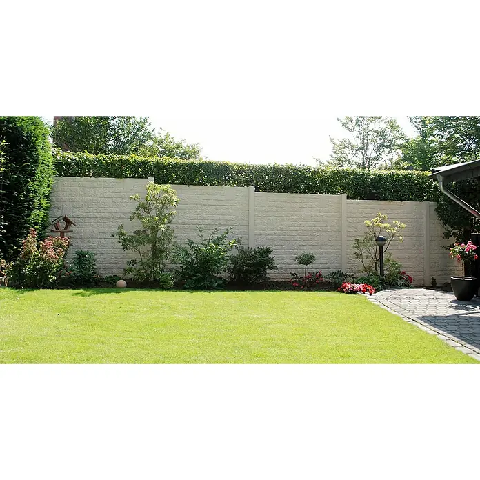 Beckers Betonzaun Zaunelement Standard Romania Motiv - 200 x 38,5 cm, Beton, Betongrau - Gepflegter Garten mit einer weißen Steinmauer als Sichtschutz, bepflanzt mit verschiedenen Pflanzen und Sträuchern. Rasenfläche und gepflasterter Weg.