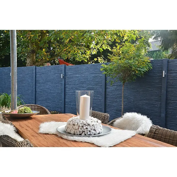Beckers Betonzaun Zaunelement Standard Toscana Motiv - 200 x 38,5 cm, Beton, Betongrau - Gartentisch mit Dekoration und Sitzgelegenheiten vor einem modernen, anthrazitfarbenen Sichtschutzzaun.