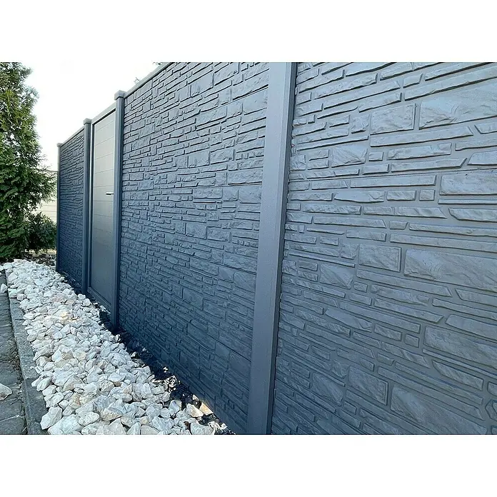 Beckers Betonzaun Zaunelement Klassik Montana Motiv - 184 x 26 cm, Beton, Betongrau - Bild einer grauen Steinmauer mit Tür und weißen Steinen am Boden. Die Mauer ist modern und stilvoll.