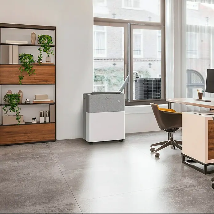 Midea Klimasplitgerät PortaSplit 12.000 Btu - Kühlleistung: 3.500 W, Heizleistung: 3.500 W, Raumgröße: 42 m² - Ein Midea Klimagerät steht in einem modern eingerichteten Raum neben einem Fenster und sorgt für angenehme Kühlung.
