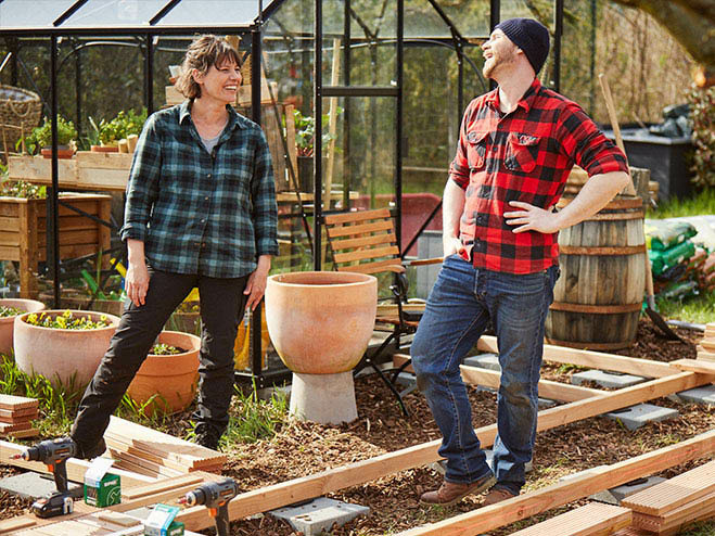 Mann und Frau stehen im Garten in der Unterkonstruktion für den Gartenweg aus Holz