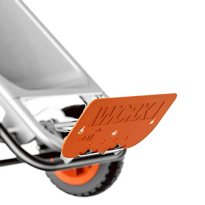 Worx Schubkarre Aerocart Multifunktion 8-in-175 l, Stahl, Traglast: 136 kg - Nahaufnahme eines Work-Gartengeräts mit einem orangenfarbenen Werkstück, das mit dem Wort "WORK" verziert ist und über einem Rad befestigt ist.