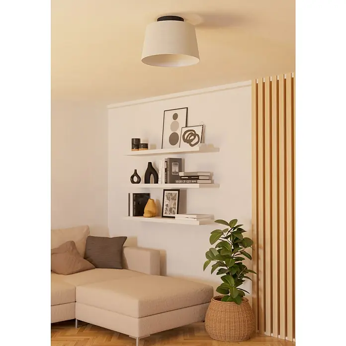 Eglo LED-Deckenleuchte Febres - 60 W, Schwarz, Weiß, Durchmesser: 35 cm - Ein beiger Deckenschirm hängt an der Decke und beleuchtet ein Wohnzimmer mit Bücherregalen, einem Sofa und einer Topfpflanze.