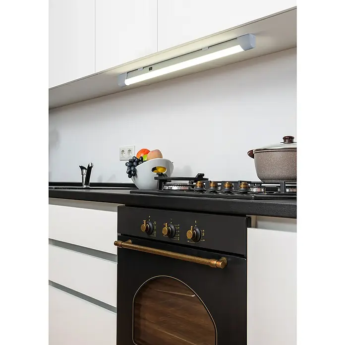 Eglo LED-Unterbauleuchte Mattanza - L x B x H: 60 x 3 x 4 cm, Lichtfarbe: Neutralweiß, 220 V - 240 V - Eine graue Unterbau-LED-Leuchte beleuchtet eine weiße Rückwand und schwarze Arbeitsplatte, mit sichtbarem Ein-/Ausschalter.