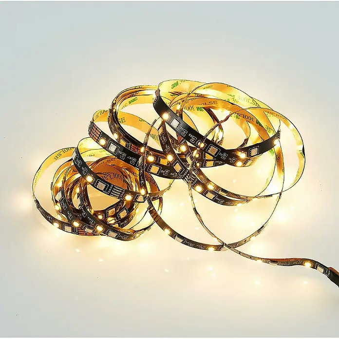 Trio Lighting Tira LED Grip - Largo: 5 m, RGB - Detalle de una tira de luz LED blanca cálida enrollada sobre una superficie clara.