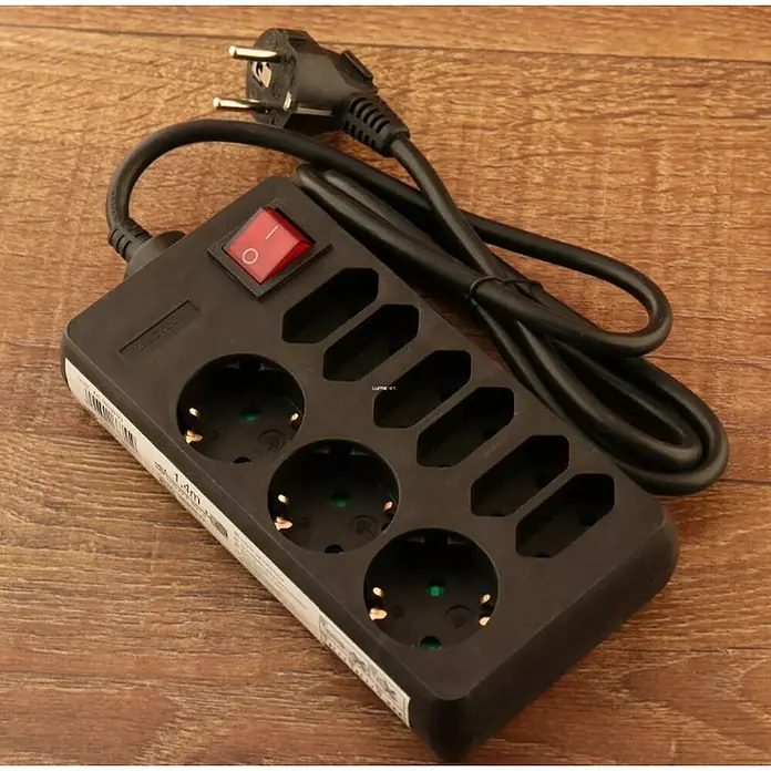 Base de enchufe múltiple - Negro, Longitud del cable: 1,4 m, Con interruptor, Número de enchufes Schuko: 3 ud. - Regleta de enchufes negra con 3 tomas, interruptor y cable de alimentación para uso en interiores sobre una superficie de madera.