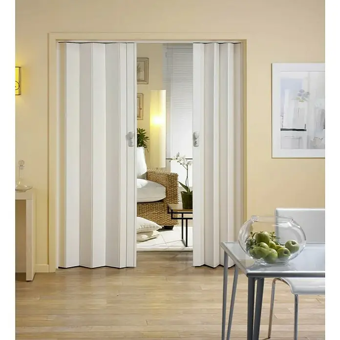 Grosfillex Lámina adicional para puerta plegable Spacy - 14,5 x 205 cm, Roble claro - Imagen de una puerta plegable que divide una abertura. La puerta es blanca y tiene un tirador. Está parcialmente abierta y revela la habitación.