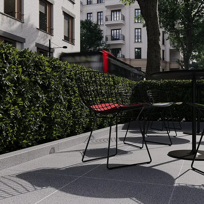 Palisade G 654 - 50 x 10 x 12 cm, Anthrazit - Ein einladender Außenbereich mit stilvollen, schwarzen Drahtstühlen mit roten Sitzkissen und einem passenden Tisch für entspannte Momente.