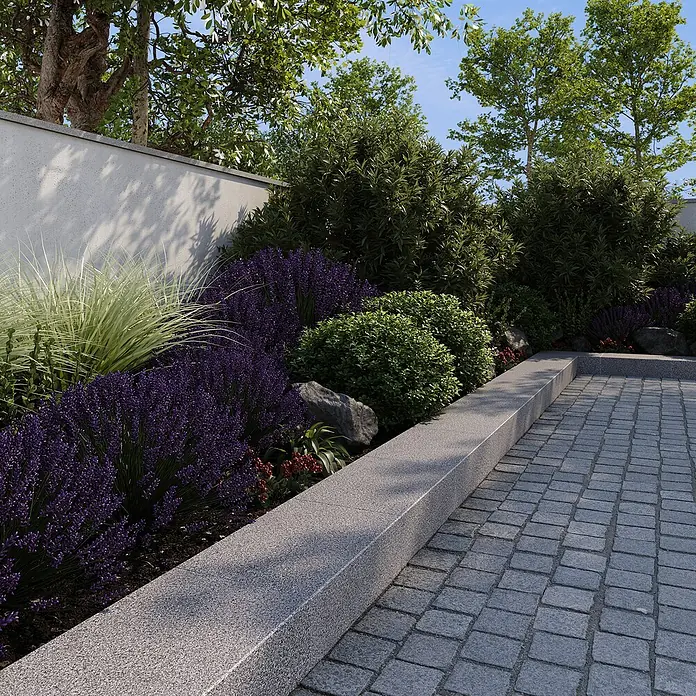Granitstufe G 654 - Anthrazit, 50 x 33 x 15 cm - Gartenmauer mit üppigen Lavendelbüschen, Ziergräsern und grünen Sträuchern, die eine friedliche und natürliche Gartengestaltung zeigen.