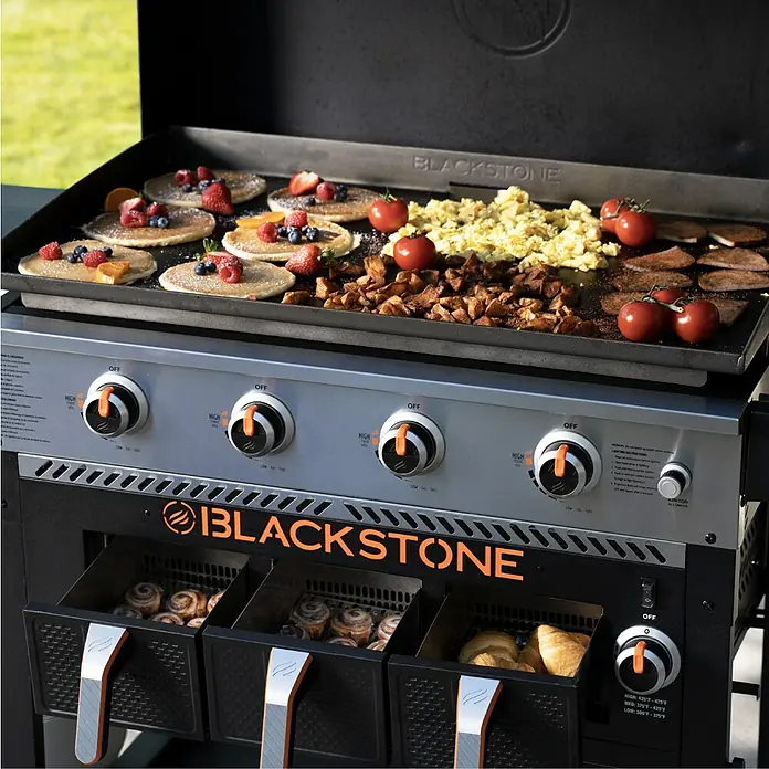 Blackstone Plancha-Grill 36" mit Airfryer - Grillfläche (B x T): 91 x 55 cm, 17,5 kW, Schwarz - Ein Blackstone Grill mit verschiedenen Speisen wie Pfannkuchen, Rührei und Zimtschnecken, ideal für vielfältige kulinarische Erlebnisse.