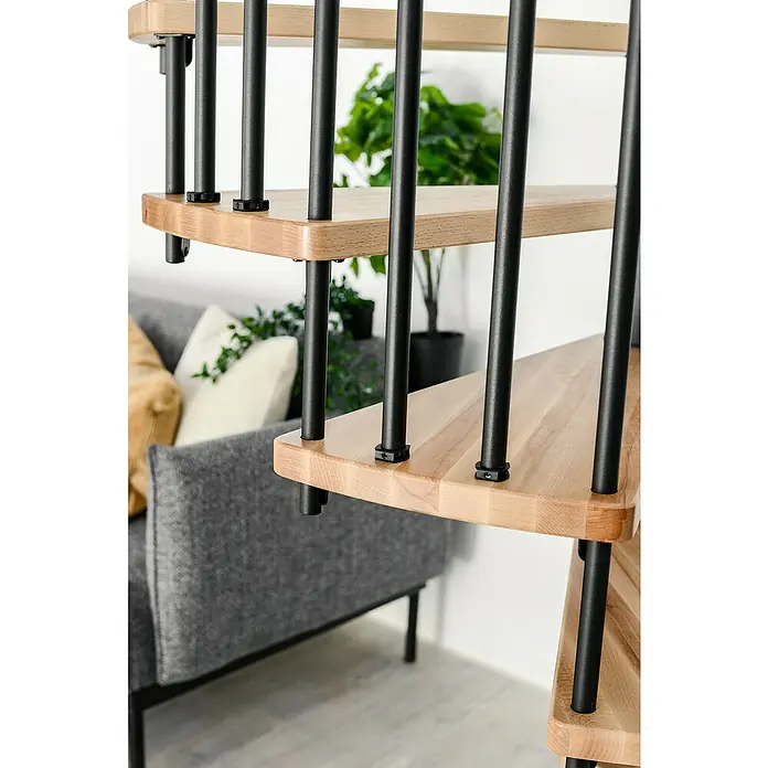 Minka Spindeltreppe Spiral Effect - Durchmesser: 140 cm, Schwarz, Farbe Stufen: Buche Natur, Geschosshöhe: 305,5 cm - Nahaufnahme einer modernen Treppe mit hellen Holzstufen und schwarzen Geländerstäben in einem stilvollen Interieur.