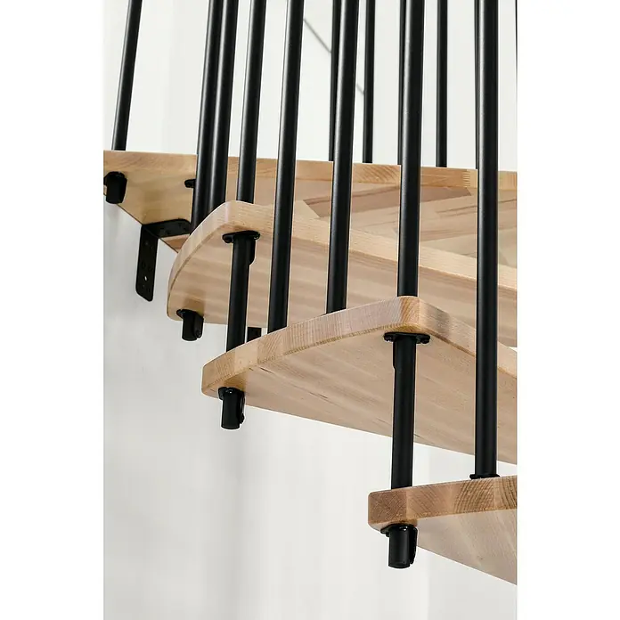 Minka Spindeltreppe Spiral Effect - Durchmesser: 140 cm, Schwarz, Farbe Stufen: Buche Natur, Geschosshöhe: 305,5 cm - Detailaufnahme einer eleganten Holztreppe mit schwarzen Geländerstäben, die ein modernes und stilvolles Designelement im Raum darstellt.