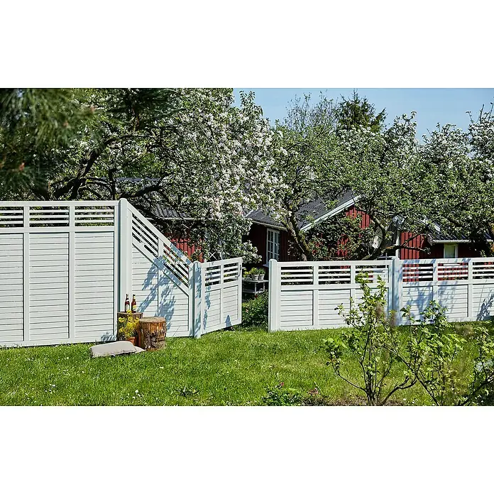 Plus Sichtschutzelement Decora - 180 x 180 cm, Holz, Weiß RAL 9010 - Weißer Lamellen-Gartenzaun mit Tor, der im sonnigen Frühlingsgarten Privatsphäre bietet.