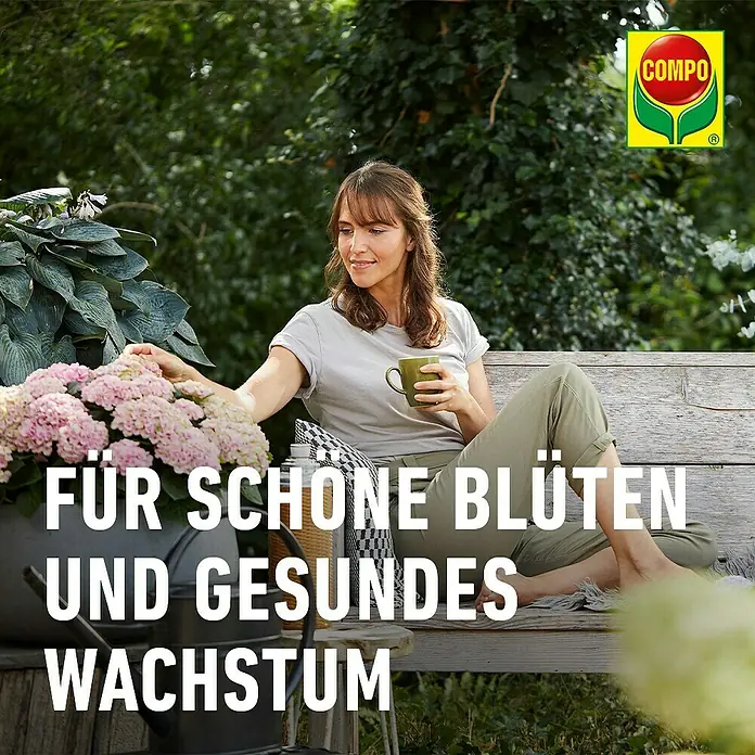 Compo Langzeitdünger Rhododendron - 2 kg - Frau genießt Garten mit leuchtend pinken Hortensien, für schöne Blüten und gesundes Pflanzenwachstum.