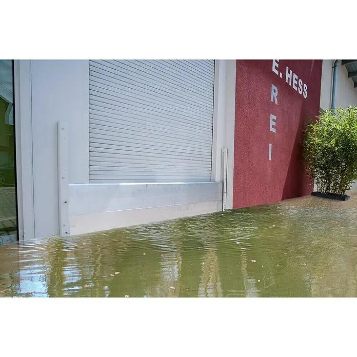 Masys Hochwasser-Kit Large - 200 x 60 cm - Diese Aufnahme zeigt eine installierte Hochwassersperre an einem Gebäude, wobei das Wasser bereits bis zu einem beträchtlichen Pegel angestiegen ist.