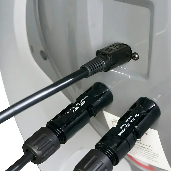 Boiler Solar - 29 l - Schwarze Elektrokabel mit Steckern, teils an Schaltkasten angeschlossen, andere bereit. Stecker tragen Warnung: 'Nicht unter Last trennen'.
