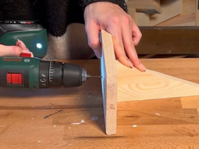 2 Holzstücke werden miteinander verschraubt, sodass eine Halterung entsteht