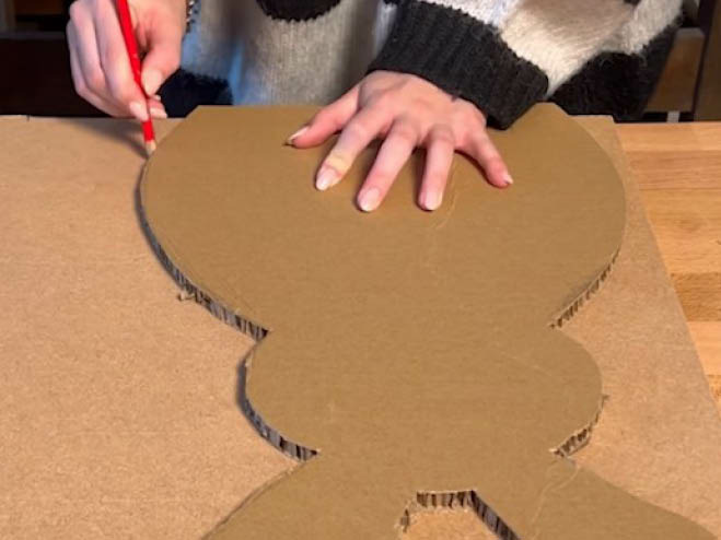Hase aus Karton wird auf eine MDF-Platte mit einem Bleistift übertragen