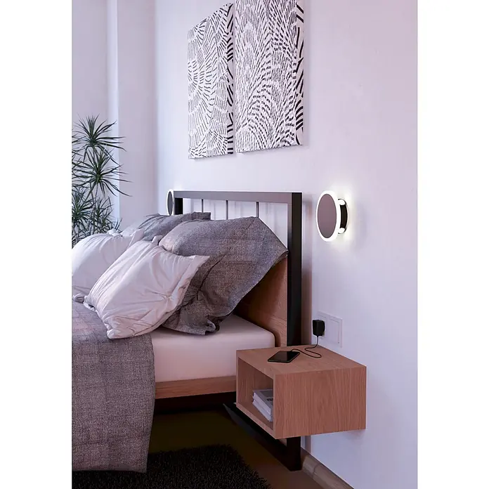 Eglo LED-Wandleuchte Talamello 1 - 12 W, Schwarz, Warmweiß, Durchmesser: 17 cm - Modernes Schlafzimmer mit schwebendem Nachttisch aus Holz und runder Wandleuchte. Graue Bettwäsche und abstrakte Wandkunst ergänzen die Einrichtung.