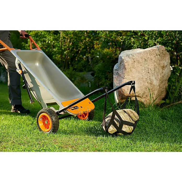 Worx Schubkarre Aerocart Multifunktion 8-in-175 l, Stahl, Traglast: 136 kg - Eine Kippkarre mit einem Stein in einer Tragevorrichtung. Ideal für Gartenarbeiten und den Transport von schweren Lasten im Freien.