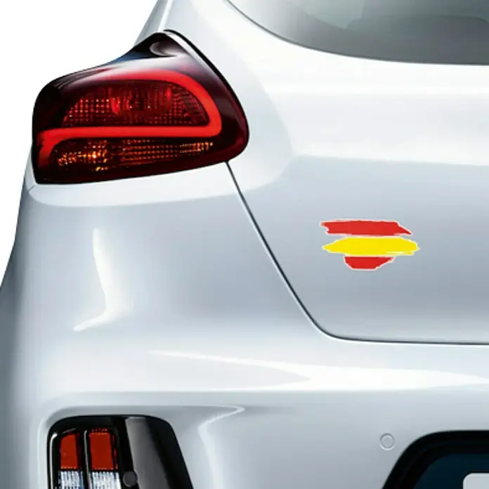Etiqueta adhesiva pincelada España - Bandera - Vista trasera de un coche blanco con una pegatina de la bandera española.