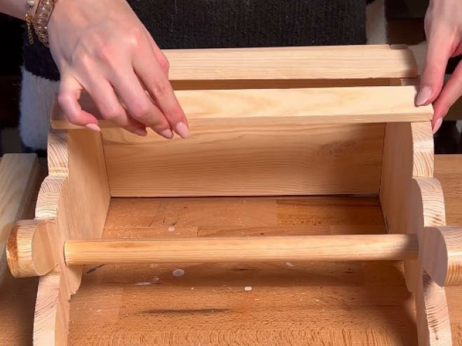 2 Holzleisten werden mit Holzleim an einer Seite des DIY Osterhasen-Korbs angeklebt