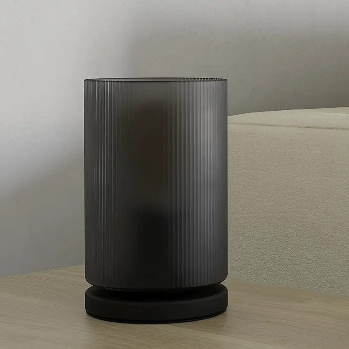 Eglo LED-Tischleuchte Colomera - 40 W, Schwarz, Ø x H: 12 x 19,5 cm - Dunkler, geriffelter zylindrischer Behälter mit schwarzem Sockel auf heller Holzoberfläche.