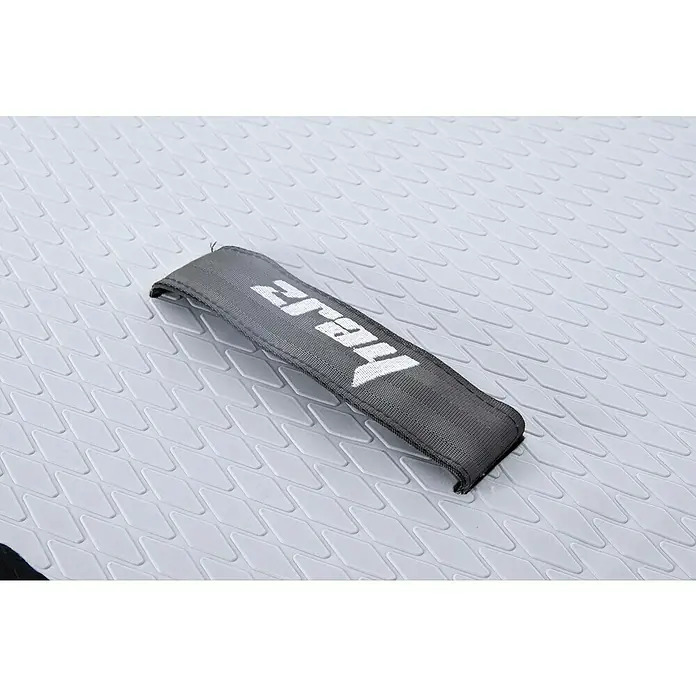 SUP-Board-Set ZRay E10 - L x B x H: 297 x 76 x 13 cm, Nutzlast: 110 kg, Aufblasbar - Detailansicht eines grauen Tragegriffs mit dem Schriftzug "Thajz" auf einem hellen, strukturierten Untergrund, vermutlich ein SUP-Board.