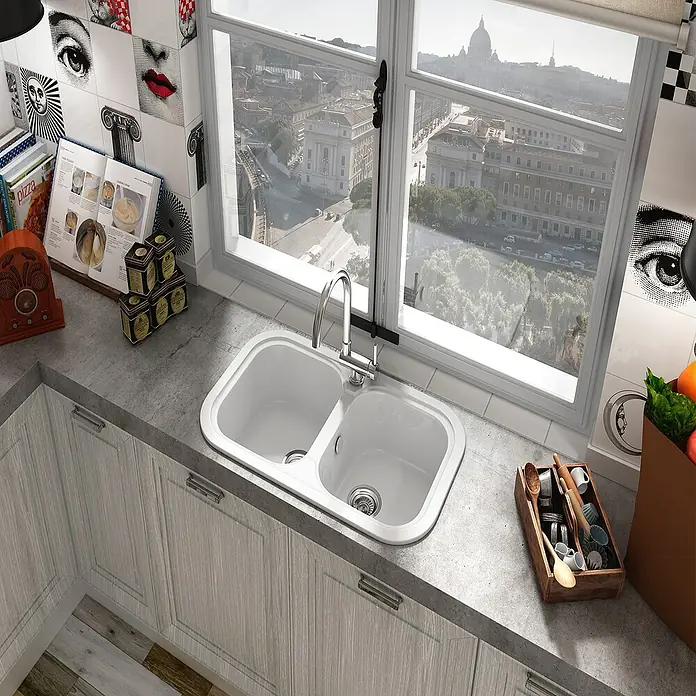 Poalgi Fregadero encastrable Esmeralda - 48,5 x 81 cm, Blanco - Un fregadero de cocina moderno de doble cubeta, integrado en una encimera gris, bajo una ventana con vistas a la ciudad.