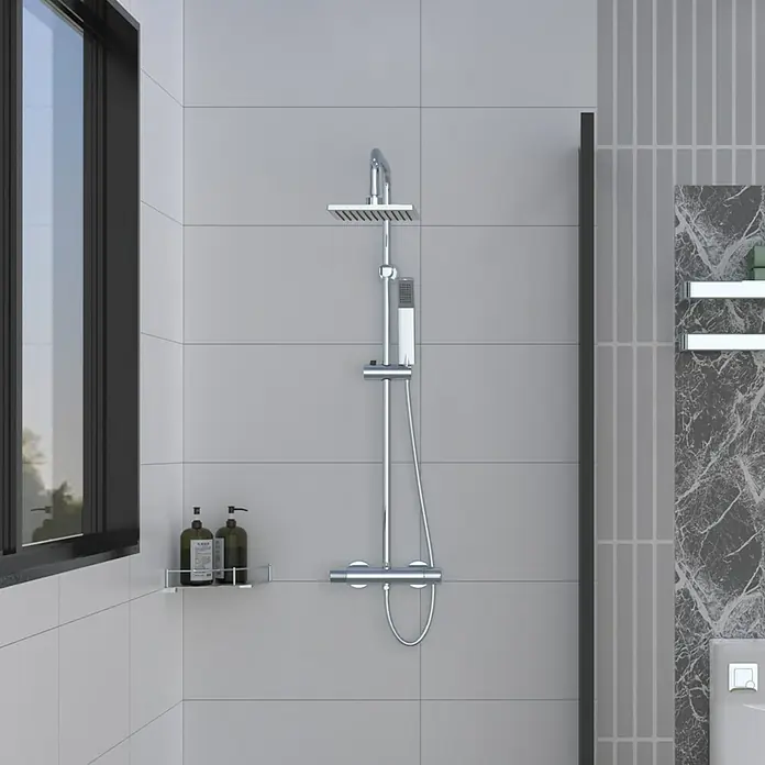 Rousseau Sistema de ducha Nessy cuadrado - Con grifo termostático, Número de tipos de chorro: 1 ud., Cromo - Un moderno conjunto de ducha cromado con rociador y ducha de mano, con una estantería para productos de ducha contra una pared gris claro.