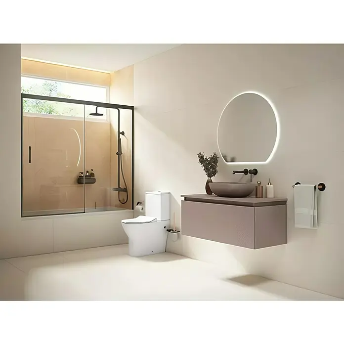 Camargue Pack de WC London - Salida dual - Interior de baño con inodoro moderno, tocador con espejo redondo y ducha a ras de suelo con marco negro.