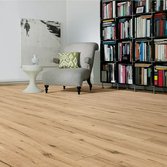 Living by Haro Laminatmuster Eiche Sahara - 290 x 193 x 7 mm, Landhausdiele - Elegantes Interieur mit hellbraunem Laminatboden, Sessel und Bücherregal. Der Laminatboden verleiht dem Raum Wärme und eine natürliche Optik.