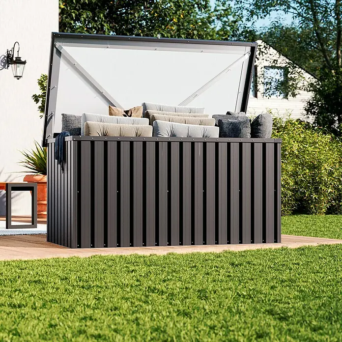 Tepro Garten-Aufbewahrungsbox Store XL - B x T x H: 184,3 x 90 x 93,8 cm, Anthrazit, Stahl - Eine offene, moderne, anthrazitfarbene Gartenbox mit wetterfesten Kissen, die auf einer Holzterrasse neben einem Rasen steht.