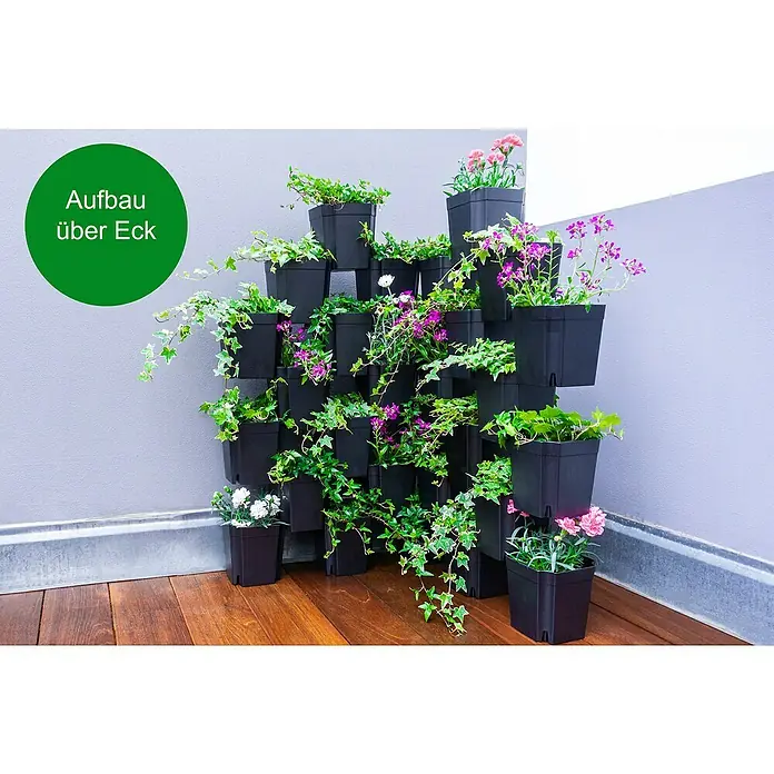 Pflanztopf Set 8er FlexiFlora - Kunststoff, Schwarz, 8 Stk. - Schwarze stapelbare Pflanzgefäße bilden ein vertikales Eckbeet, gefüllt mit grünem Efeu und bunten Blumen.