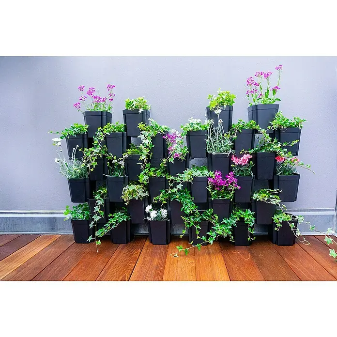 Pflanztopf Set 8er FlexiFlora - Kunststoff, Schwarz, 8 Stk. - Vertikaler Garten mit schwarzen Töpfen voller Pflanzen auf Holzterrasse. Ideal für kleine Räume, um einen Hauch von Natur und Farbe hinzuzufügen.