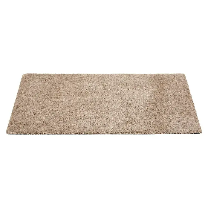 Fußmatte Moon - Taupe, 100 x 60 cm, 100 % Polyester - Nahaufnahme eines beigefarbenen Teppichs mit kurzem Flor, der eine weiche und einladende Textur zeigt, ideal für Wohnbereiche.