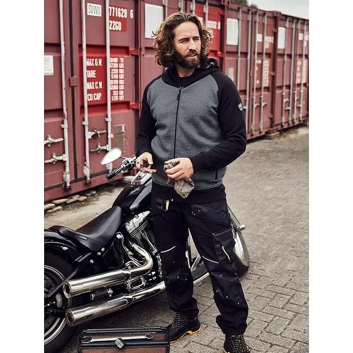 Terrax Workwear Herren-Arbeitshose - 54, Schwarz/Gelb - Modische Arbeitskleidung: Graue Kapuzenjacke mit schwarzen Ärmeln und robuste schwarze Arbeitshose mit gelben Akzenten, ideal für den professionellen Einsatz.
