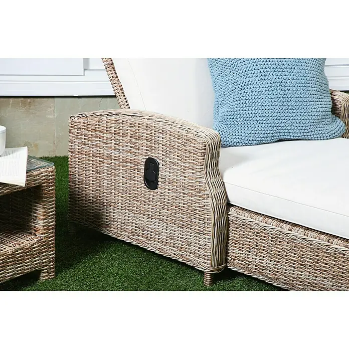 Tumbona de jardín Gotland - 83,5 x 206 x 26 cm, Arena, Acero, Respaldo regulable - Primer plano de una butaca de ratán con una palanca negra para reclinar, complementada con un cojín azul.