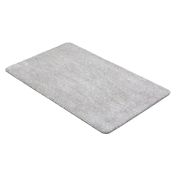 Fußmatte Moon - Hellgrau, 100 x 60 cm, 100 % Polyester - Ein weicher, rechteckiger, grauer Teppich mit kurzem Flor, der auf einem dunklen Hintergrund liegt, ideal für Badezimmer oder Schlafzimmer.